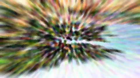 Abstraktes Bild mit radialer Unschärfe: bunte Streifen in Grün, Rosa, Gelb und Weiß laufen von einem dunklen Zentrum nach außen.