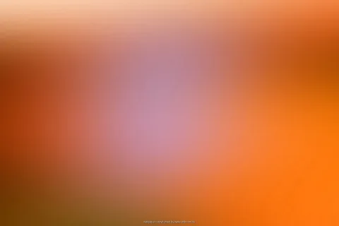 Unscharfer Farbverlauf von Orange über Rotbraun bis Lila, in der Mitte ein heller lilafarbener Fleck.