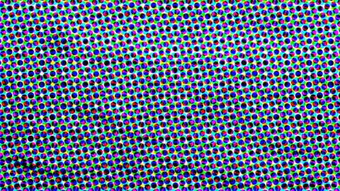 Dichtes, versetztes Raster aus kleinen farbigen Punkten in Rot, Blau, Magenta und Schwarz vor einem grellen Hintergrund aus Grün und Cyan.
