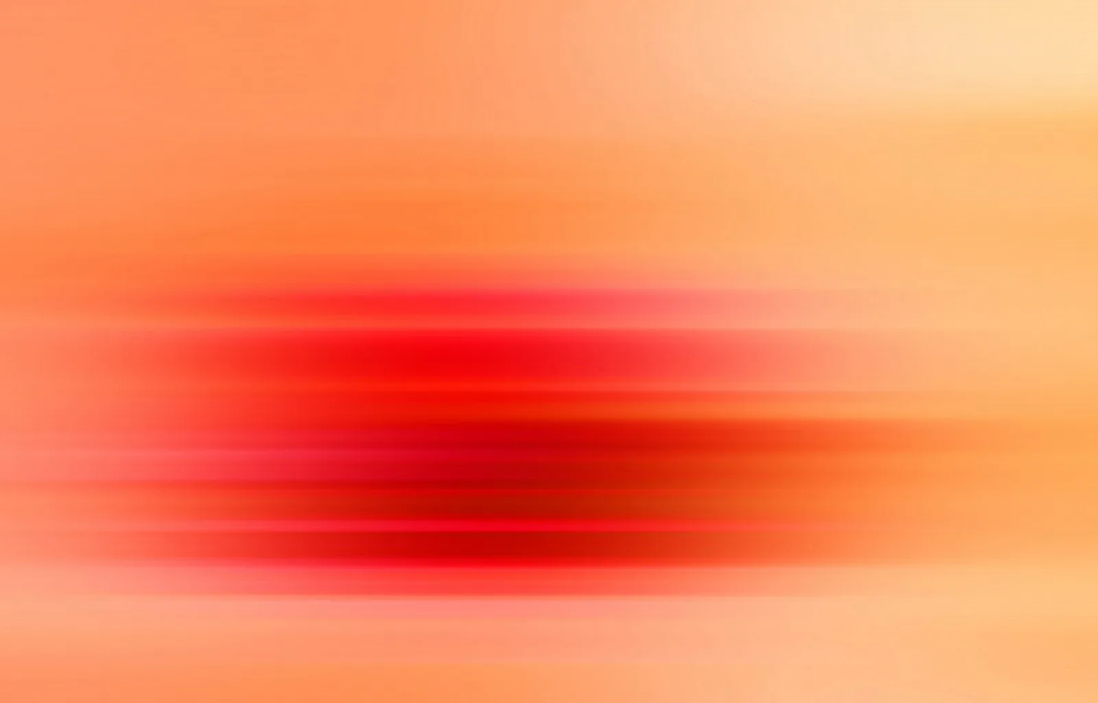 Horizontal verwischte rote und orangefarbene Streifen, in der Mitte am dunkelsten und zu den Rändern hin heller werdend.