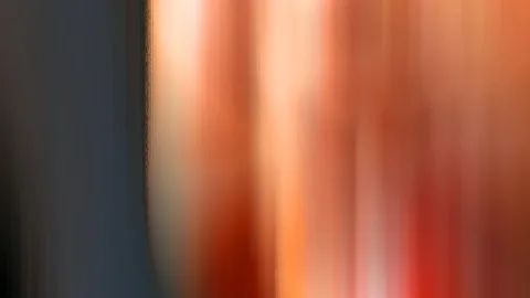 Abstrakte, stark verwischte senkrechte Streifen: links dunkles Graublau, rechts Orange, Rot und Cremeweiß.