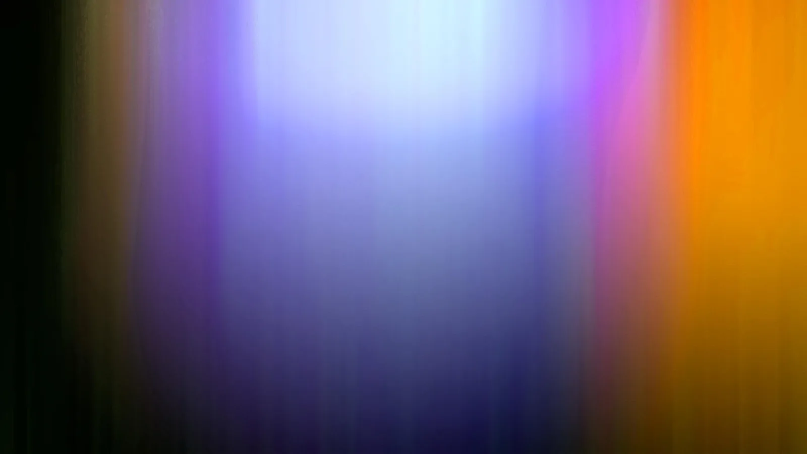 Abstrakte, vertikal verwischte Lichtstreifen in Violett, Blau und Orange auf dunklem Grund