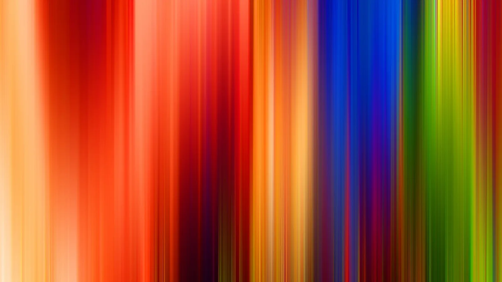 Vertikal verwischte Lichtstreifen in Rot, Orange, Blau, Violett und Grün, die von links nach rechts ineinander übergehen.
