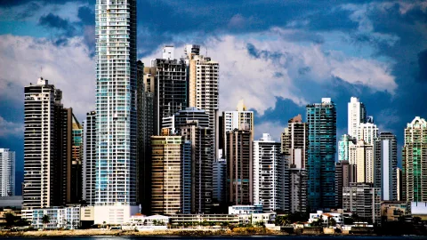 Dichte Hochhausreihe an der Küste von Panama City unter dunkelblauem Himmel mit weißen Wolken