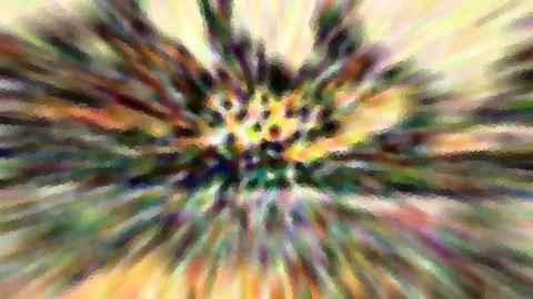 Abstrakte Zoom-Unschärfe mit strahlenförmigen Schlieren in Grün, Gelb, Violett und Orange, die von einem hellen Zentrum in der Bildmitte ausgehen.