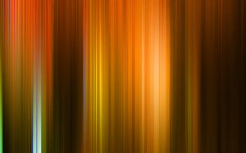 Abstraktes Bild aus vertikalen, unscharfen Streifen in Orange, Braun und Gelb, in der Mitte leuchtet ein heller Lichtbereich.