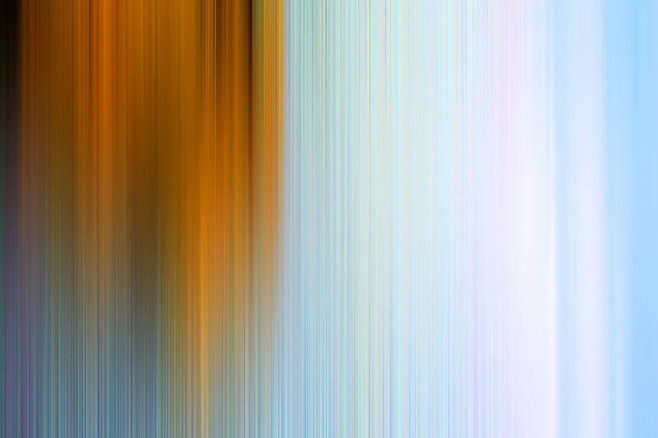 Abstraktes Bild aus senkrechten, verwischten Streifen: links warmes Orange und Braun, rechts helles Blau und Weiß.