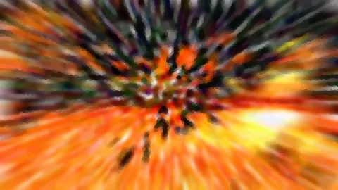 Abstrakte Unschärfe mit orangefarbenen und gelben Strahlen, die von einem dunklen, grünlich schwarzen Zentrum nach außen laufen.