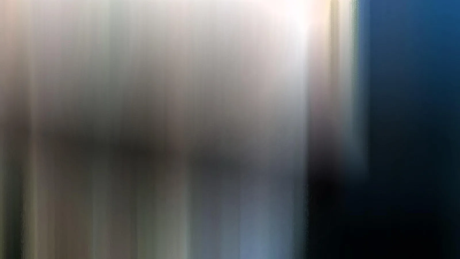Abstrakte, vertikal verwischte Fläche mit hellen beigen und grauen Streifen links und einer dunkelblauen, fast schwarzen Fläche rechts.