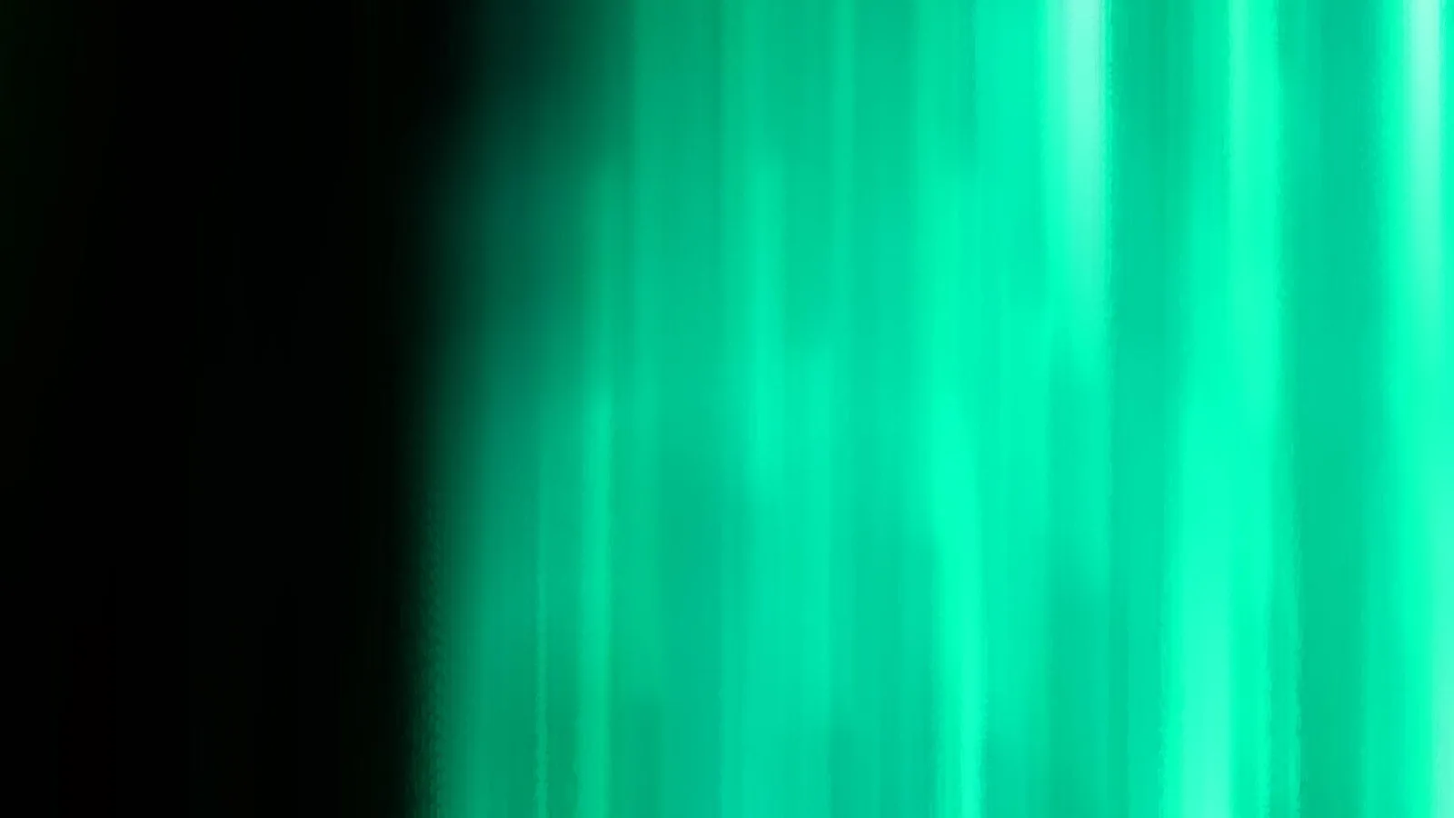 Vertikale grüne Lichtschlieren auf der rechten Bildhälfte, links verläuft das Bild in dunkles Schwarz.