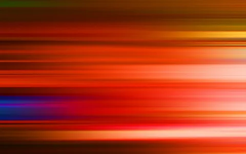 Abstrakte horizontale Streifen in Rot, Orange und Gelb mit einzelnen blauen und violetten Akzenten, die unscharf ineinander übergehen.