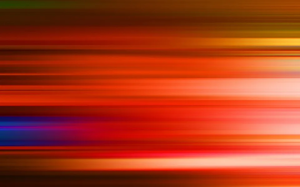 Abstrakte horizontale Streifen in Rot, Orange und Gelb mit einzelnen blauen und violetten Akzenten, die unscharf ineinander übergehen.