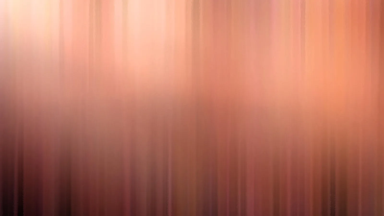 Abstrakte, vertikal verwischte Streifen in Rosa und Orange, oben heller, unten dunkler.