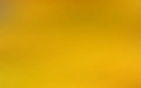 Unscharfer Verlauf in Gelb- und Ockertönen, von dunkleren Orangetönen oben zu hellem Gelb unten, ohne erkennbare Motive.