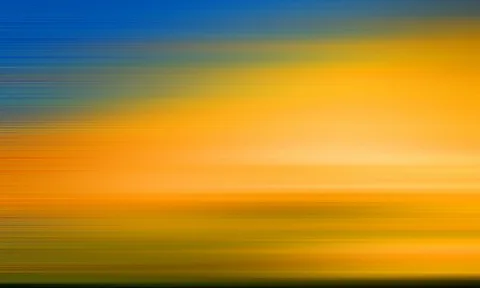 Horizontale Bewegungsunschärfe mit einem blauen Band oben, das in warmes Orange und Gelb übergeht, unten dunkles Grün.