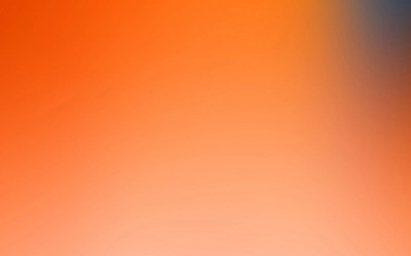 Unscharfer Verlauf von Orange im Vordergrund bis Hellrosa unten, oben rechts ein blaugrauer Schimmer.