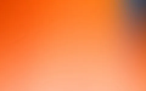 Unscharfer Verlauf von Orange im Vordergrund bis Hellrosa unten, oben rechts ein blaugrauer Schimmer.
