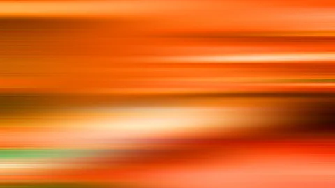 Horizontale, verwischte Lichtstriche in Orange, Gelb und Weiß, durchzogen von einem grünen Streifen am unteren Rand.