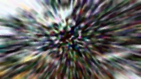 Abstraktes Bild mit radialer Bewegungsunschärfe. Von einem dunklen Zentrum in der Mitte strahlen bunte Streifen in Grün, Violett, Weiß und Gelb nach außen.