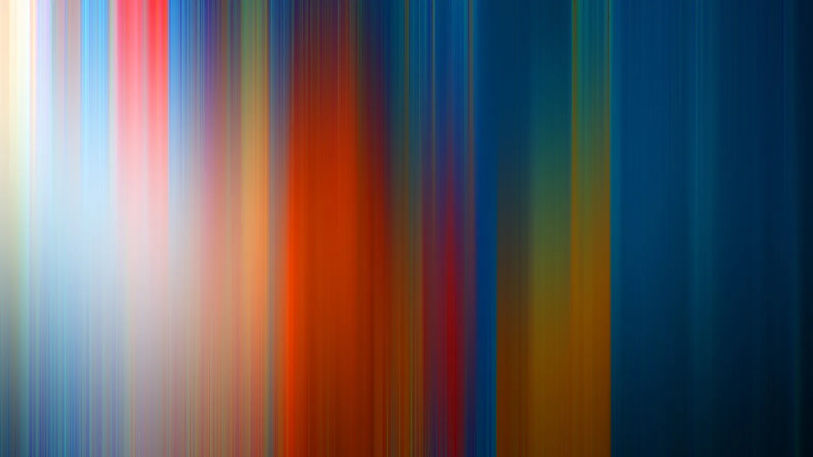 Abstrakte Komposition aus vertikalen, verwischten Farbstreifen in Weiß, Blau, Rot, Orange, Gelb und Dunkelblau, von links hell nach rechts dunkler werdend.