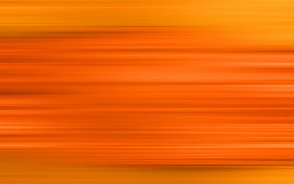 Horizontal verwischte Streifen in Orange- und Gelbtönen, die von links nach rechts zu verlaufen scheinen.