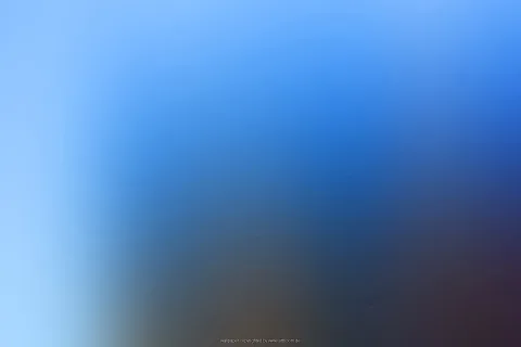 Weich verschwommener Farbverlauf von hellem Himmelblau links über kräftiges Blau bis zu dunklem Braun und Violett unten rechts.