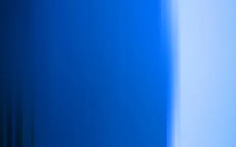 Vertikal verwischte Streifen in Blau, links dunkelblau, nach rechts hellblau auslaufend mit hellem Lichtband am rechten Rand.