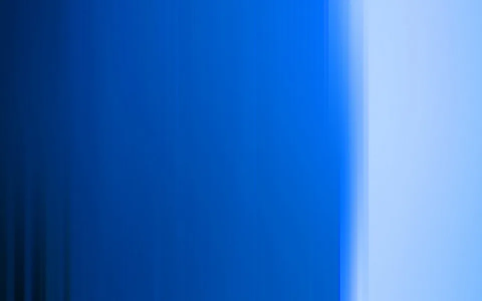 Vertikal verwischte Streifen in Blau, links dunkelblau, nach rechts hellblau auslaufend mit hellem Lichtband am rechten Rand.