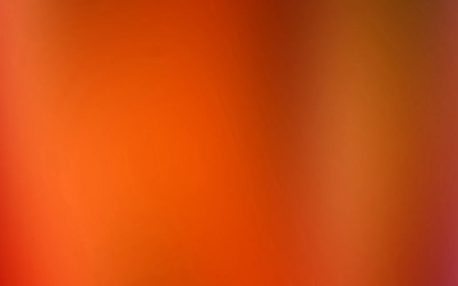 Unscharfer Verlauf aus Orange und Rot, links heller, rechts dunkler mit goldbraunen Tönen und einem Hauch Magenta in der unteren rechten Ecke.