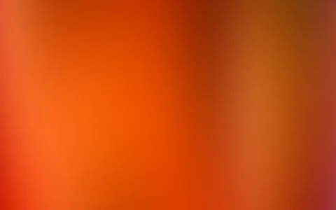 Unscharfer Verlauf aus Orange und Rot, links heller, rechts dunkler mit goldbraunen Tönen und einem Hauch Magenta in der unteren rechten Ecke.