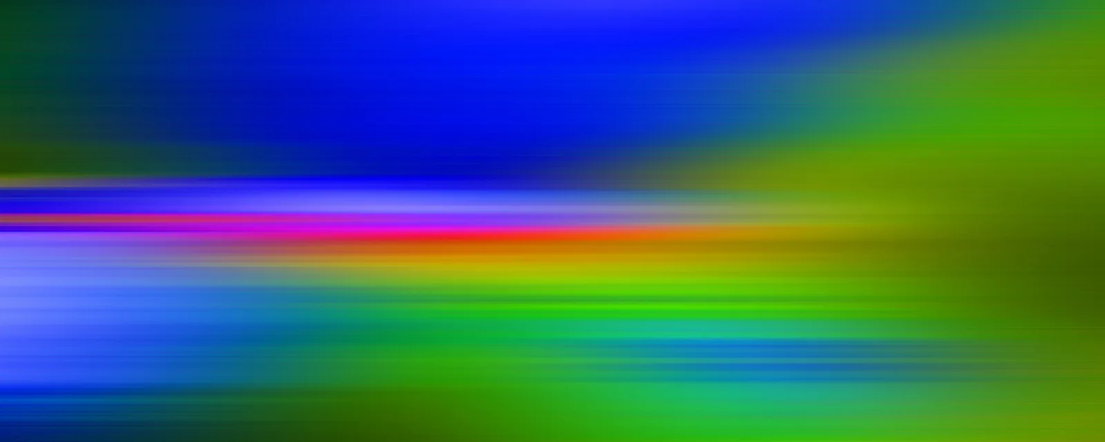 Horizontal verwischte Lichtstreifen in Blau, Grün, Magenta und Orange