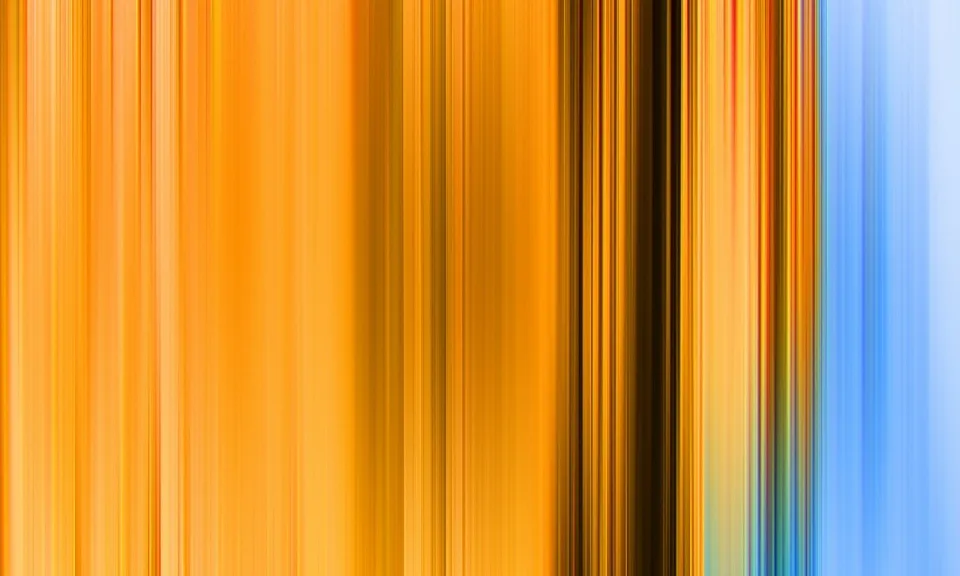 Vertikal verwischte Streifen in Orange, Gelb, Dunkelbraun und Hellblau nebeneinander.