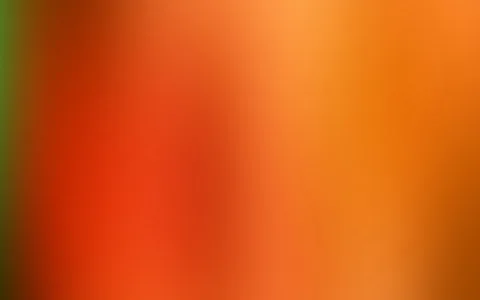 Unscharfer Farbverlauf von Rot über Orange bis Gelbocker, am linken Rand ein grüner Streifen.