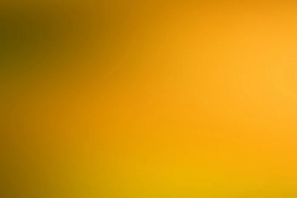 Unscharfer Farbverlauf von dunklem Olivbraun links oben über Orange bis zu hellem Gelb unten rechts