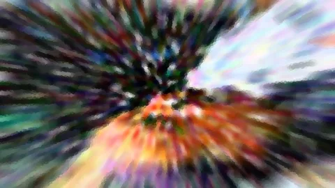 Abstrakte Komposition aus bunten, radial verwischten Farbstreifen, die von einem dunklen Zentrum nach außen strahlen, mit grünen, orangen und hellblauen Tönen.