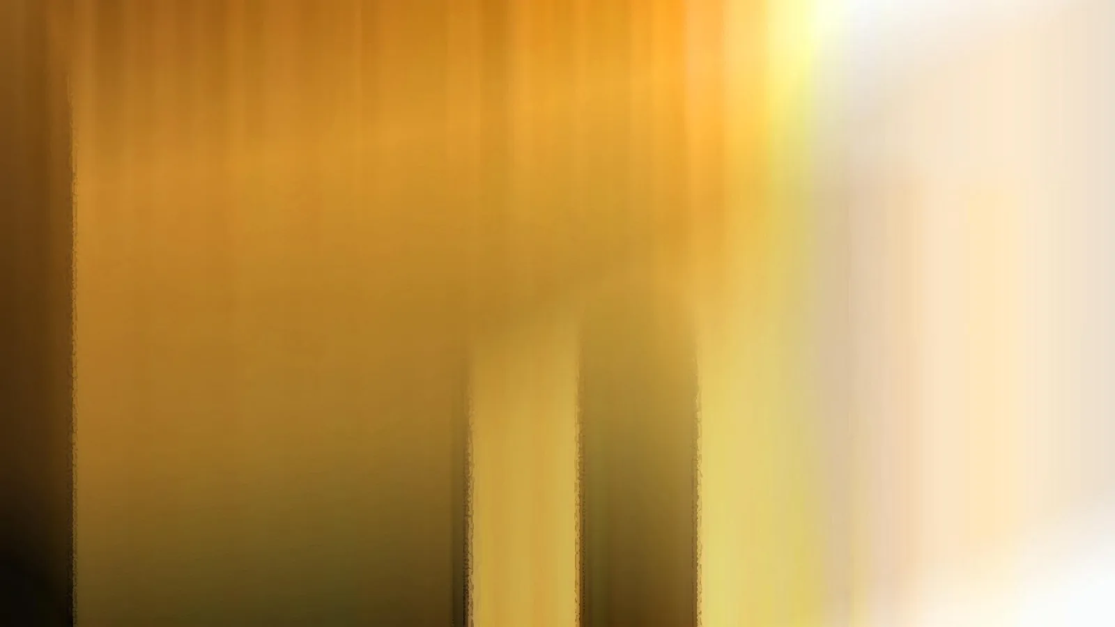 Unscharfe vertikale Streifen in Gold und Ocker, nach rechts hin in helles Creme verblassend, mit zwei dunkleren Feldern in der Bildmitte.