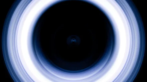 Ein leuchtender blau-weißer Ring aus feinen Streifen umgibt einen tiefschwarzen Kreis mit einem kleinen Lichtpunkt in der Mitte.