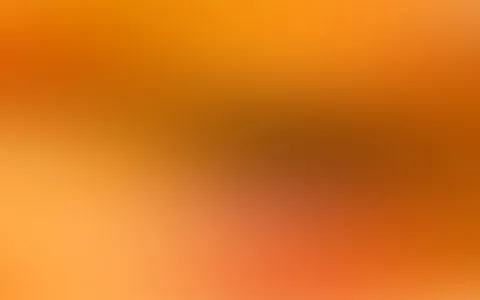 Unscharfer Farbverlauf in Orange, Gelb und Braun mit hellen und dunklen Bereichen.