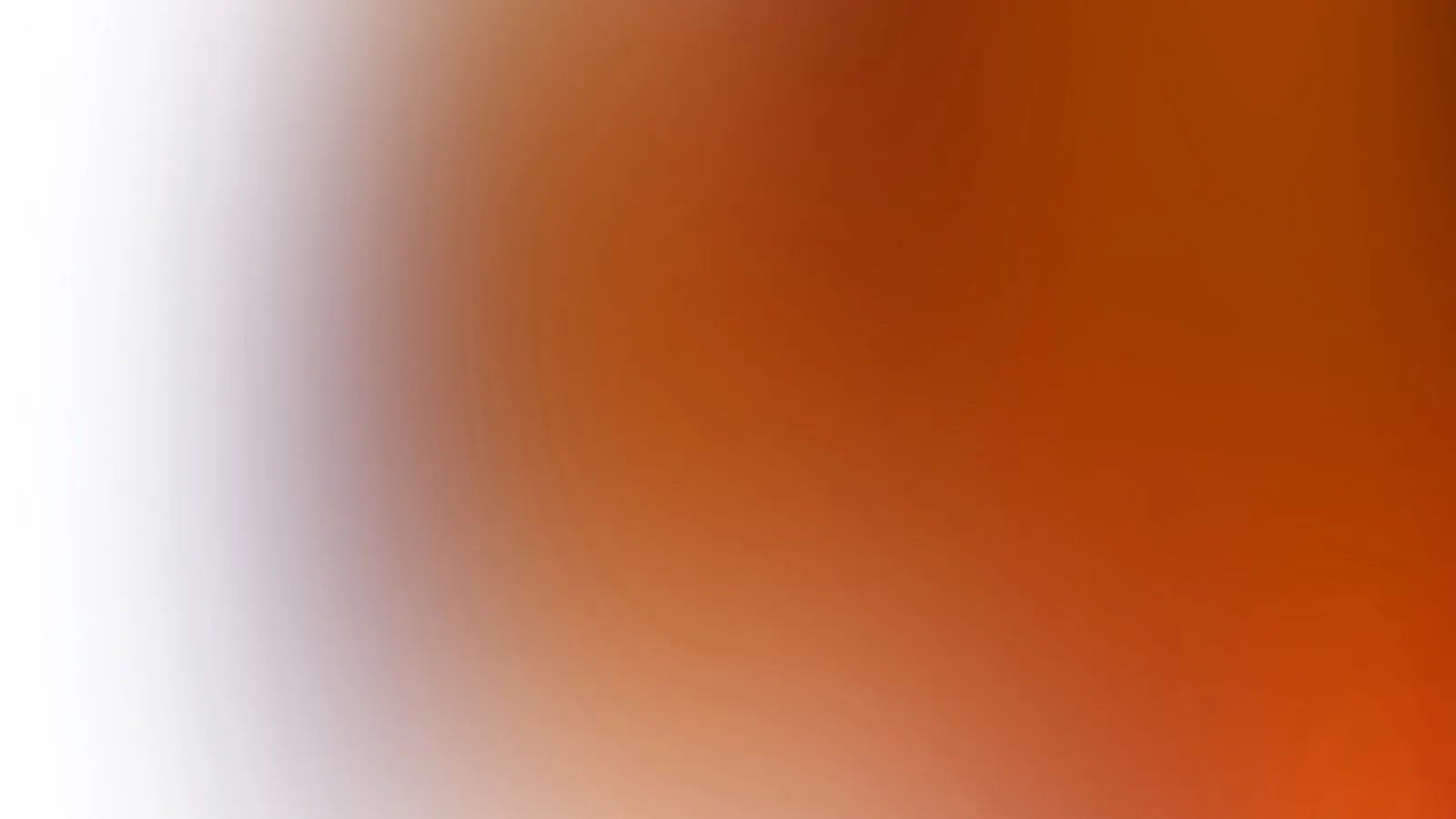 Unscharfer Farbverlauf von Weiß über Lavendelgrau in warmes Orange und Braun, rechts unten leuchtend rötlich orange.