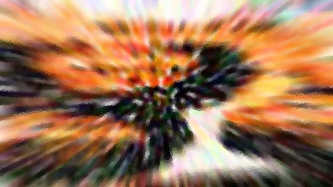 Abstrakte Komposition aus Orange, Grün und dunklen Streifen, die radial von einem hellen Zentrum ausgehen und pixelig verwischt wirken.
