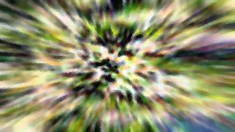 Farbige Bewegungsunschärfe mit radial vom Zentrum ausgehenden Streifen, dominiert von Grün-, Gelb- und Weißtönen, im Mitte heller.
