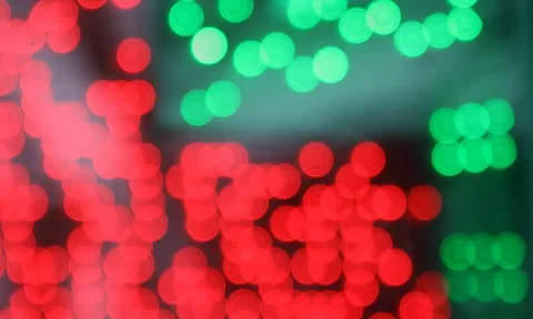 Unscharfe rote und grüne Lichtkreise vor dunklem Hintergrund