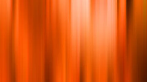 Verwischte vertikale Streifen in Orange und Rotorange, heller Lichtschein in der Bildmitte