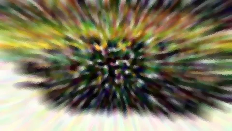 Abstrakte Komposition aus radial verwischten Farbstrahlen in Grün, Gelb, Violett und Weiß, die von einem dunklen Zentrum nach außen laufen und mosaikartig gepixelt wirken.