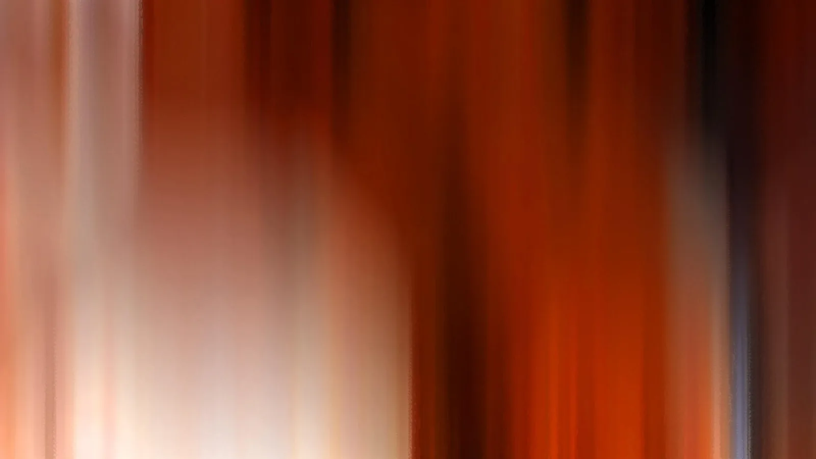 Abstrakte Komposition aus senkrechten, verwischten Streifen in Orange, Rot und Braun, links hell auslaufend ins Weiß.