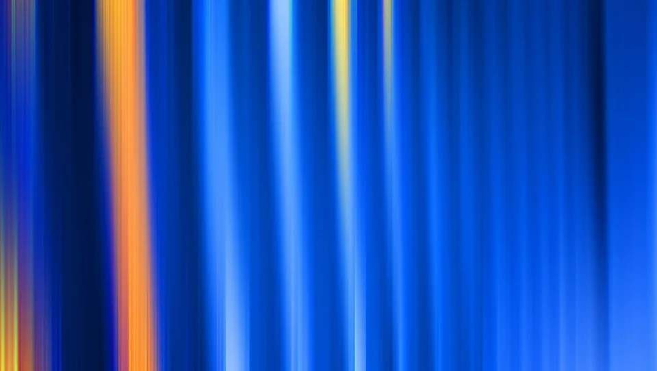 Vertikale, unscharfe Streifen in Blau mit einzelnen orangefarbenen und gelben Lichtbahnen.