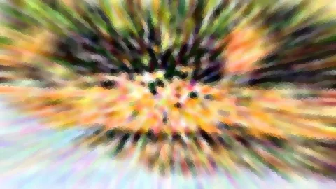 Abstraktes Bild aus radial verwischten, bunten Farbflächen in Orange, Grün und Violett, unten links ein heller bläulicher Bereich.