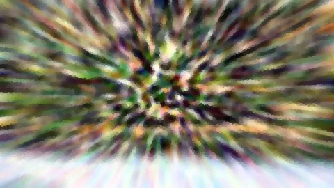 Abstraktes Bild mit radial verwischten Farbstrahlen in Grün, Lila, Weiß und Orange, die von einem hellen Zentrum nach außen laufen, mit mosaikartiger Pixelstruktur.