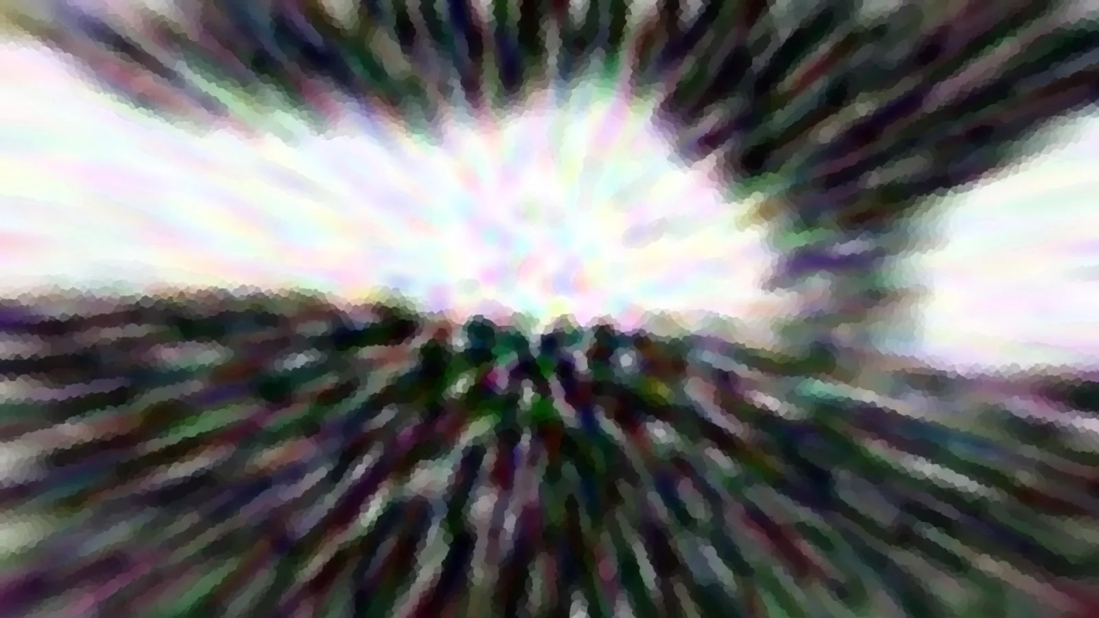 Stark verwischte Aufnahme mit radialen Streifen, in der Mitte helles Weiß, außen dunkles Grün und Violett.