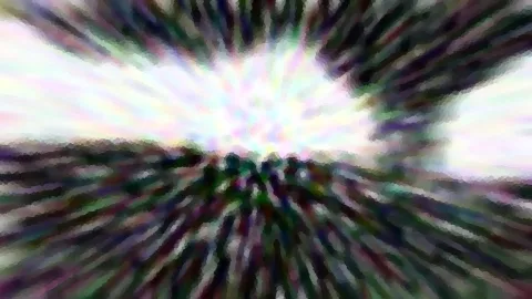 Stark verwischte Aufnahme mit radialen Streifen, in der Mitte helles Weiß, außen dunkles Grün und Violett.